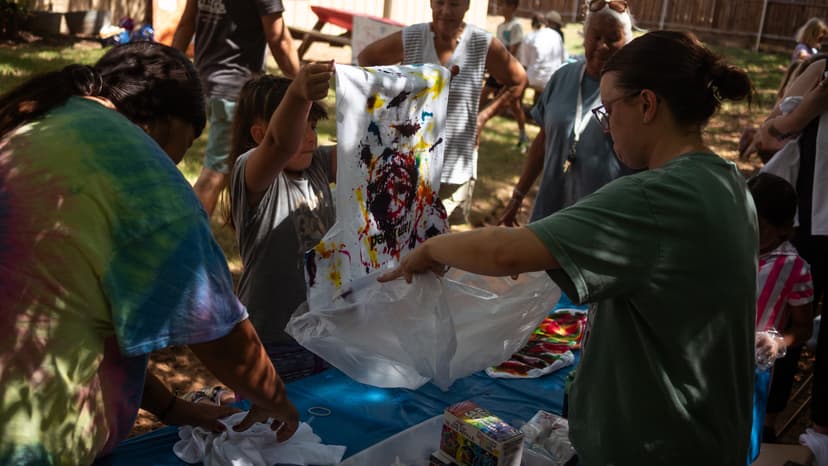 Kids tie-dying shirts with volunteer support